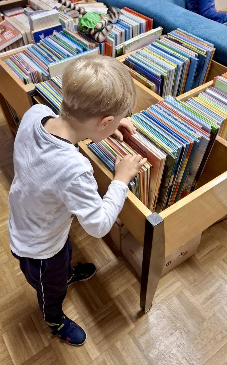 Kind wählt Buch aus